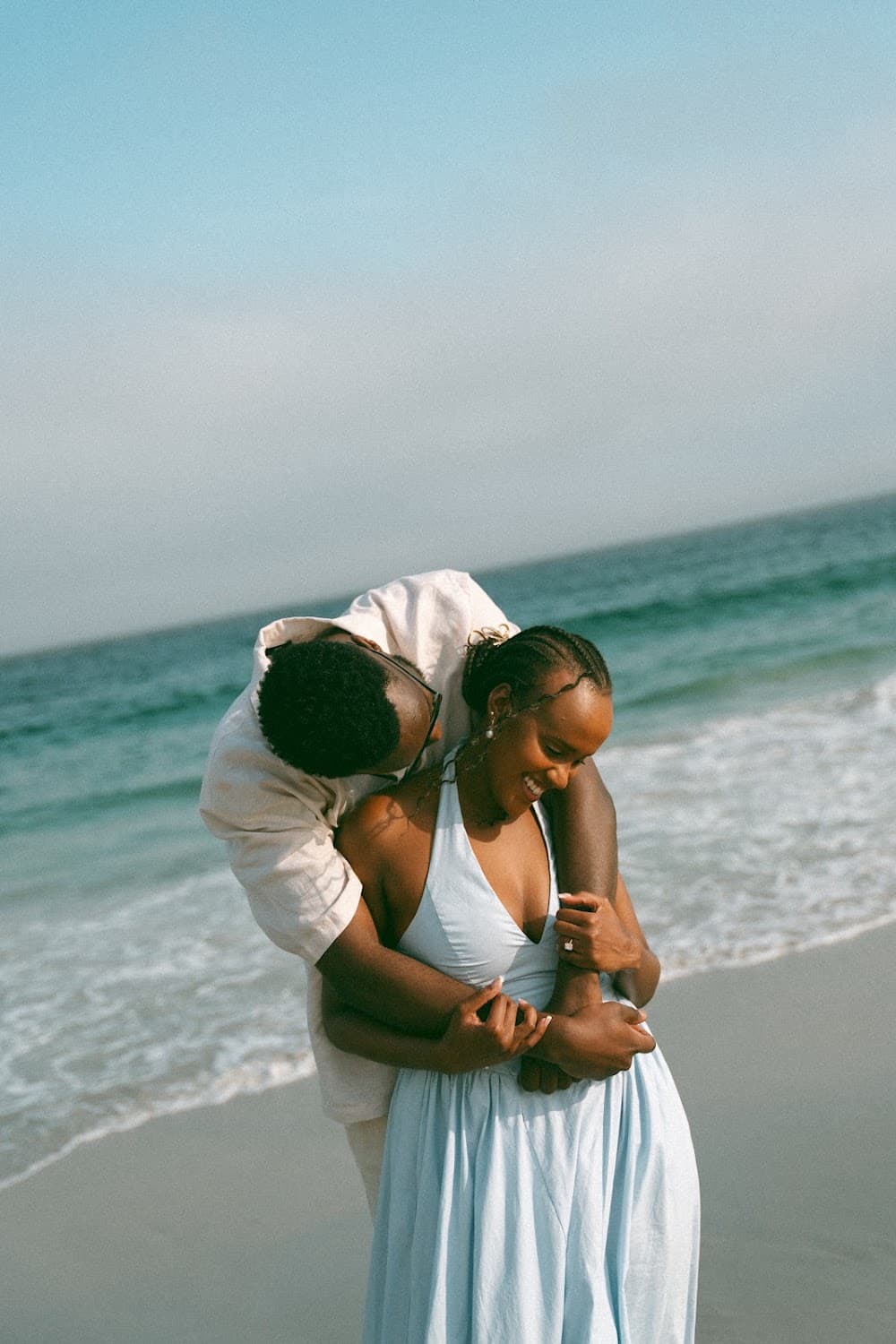 Joshua embracing Sandrine on the beach